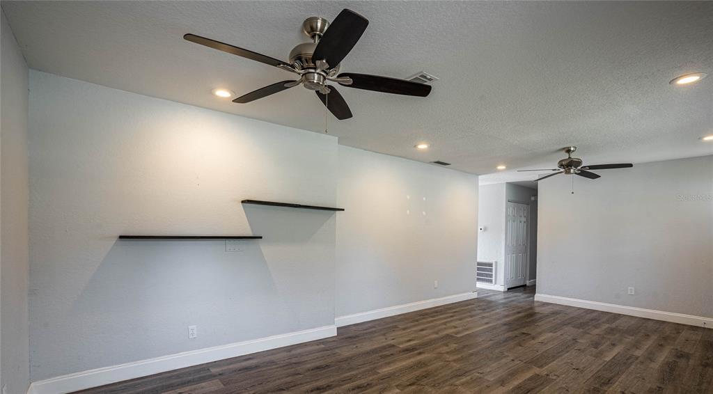 2814 William Lane Lakeland, FL 33812 - Photo 6 of 18 a view of an empty room with wooden floor and a ceiling fan