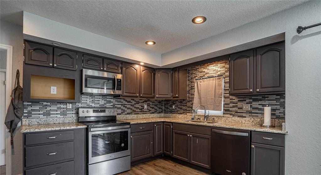 2814 William Lane Lakeland, FL 33812 - Photo 9 of 18 a kitchen with stainless steel appliances granite countertop a sink stove and cabinets