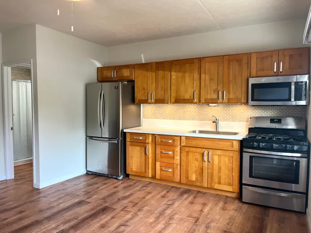 a kitchen with granite countertop a refrigerator stove and microwave