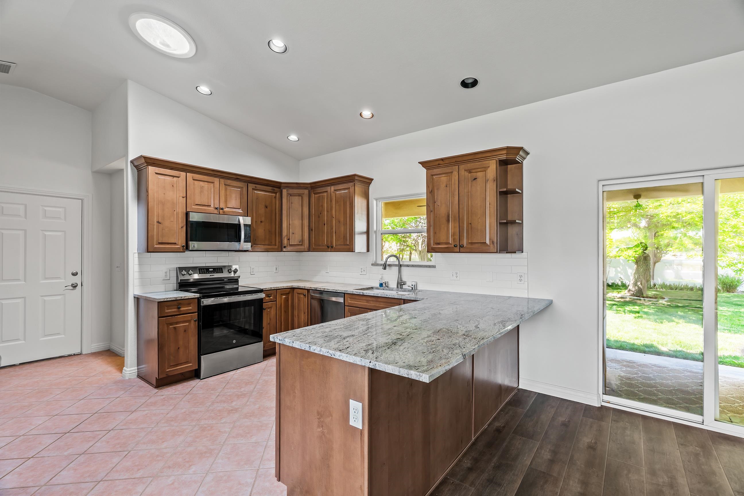 705-24 24 3/4 Road Grand Junction, CO 81505 - Photo 5 of 27 a kitchen with granite countertop kitchen island wooden cabinets and stainless steel appliances
