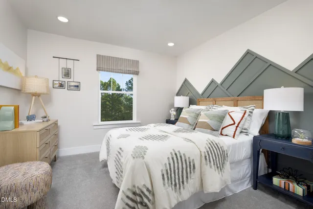 a bedroom with a bed a dresser and next to a window