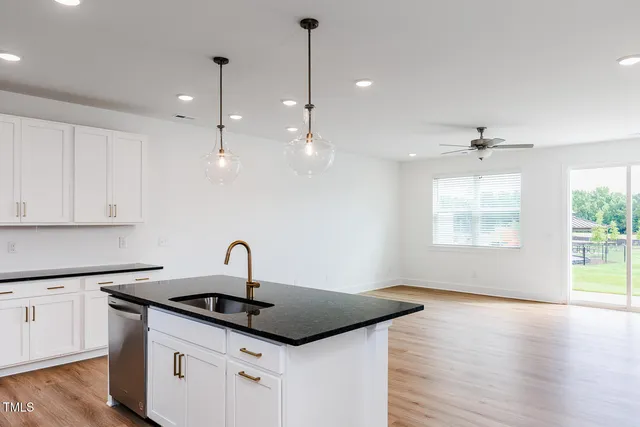 a kitchen with sink stove and wooden floor