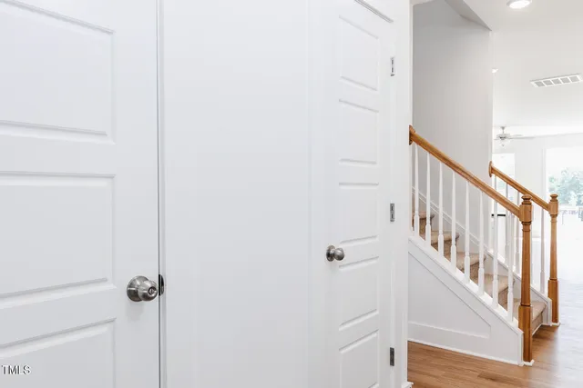 a view of a hallway with wooden floor and staircase