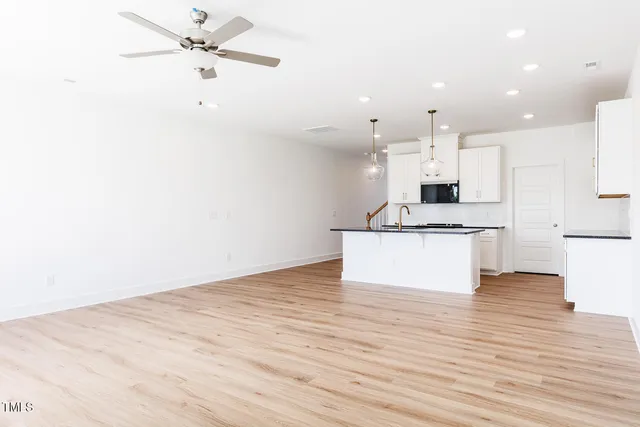 a view of kitchen with granite countertop cabinets and refrigerator