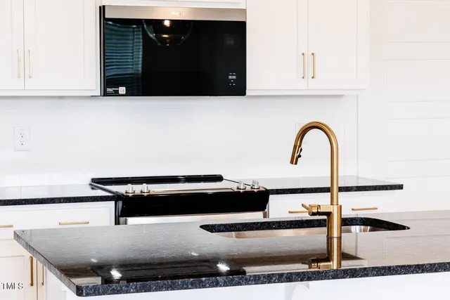 a kitchen with a stove a sink and a cabinets