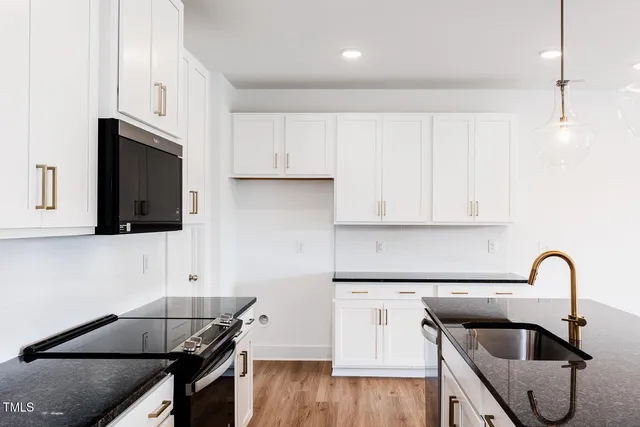 a kitchen with granite countertop a sink and a stove top oven