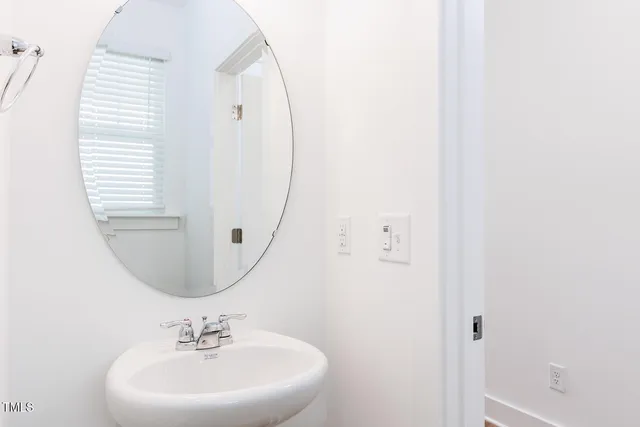 a bathroom with a sink a mirror a vanity and toilet