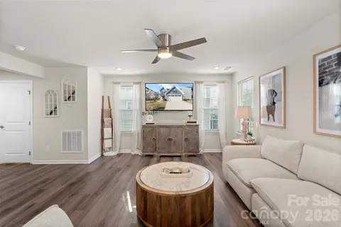a living room with furniture and a wooden floor