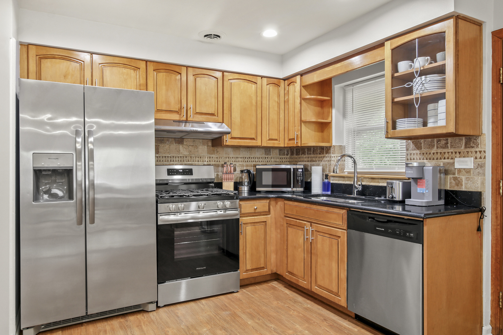 236 Callan Avenue, Unit 2 Evanston, IL 60202 - Photo 3 of 14 a kitchen with stainless steel appliances granite countertop a refrigerator a sink dishwasher a stove and white countertops with wooden floor