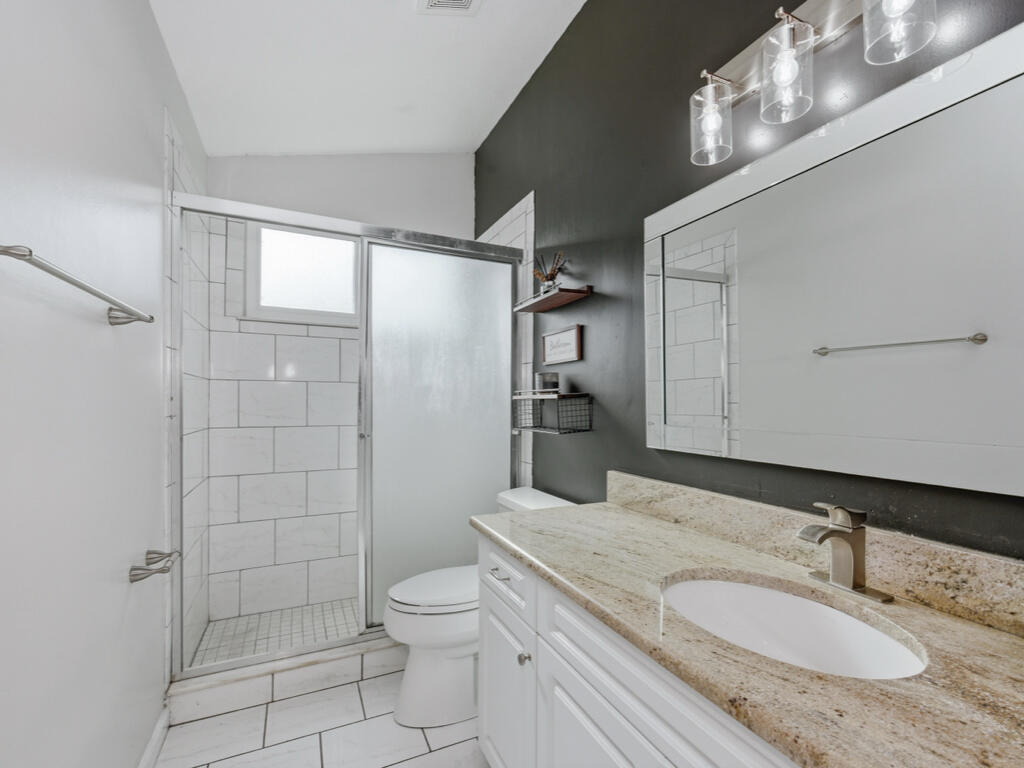 3650 Kent Drive Naples, FL 34112 - Photo 9 of 17 a bathroom with a granite countertop sink toilet and shower