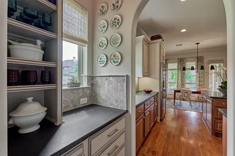 a kitchen with stainless steel appliances kitchen island granite countertop a stove a sink and a wooden floor