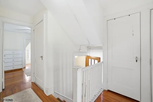 a view of a hallway with wooden floor and entryway