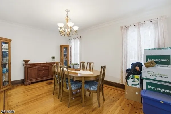 a dining room with furniture a chandelier and wooden floor