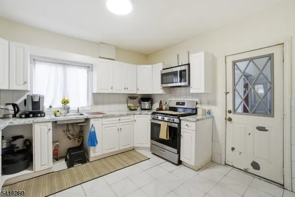 a kitchen with a stove top oven sink and cabinets