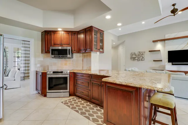 a utility room with stainless steel appliances granite countertop a sink and a white cabinets