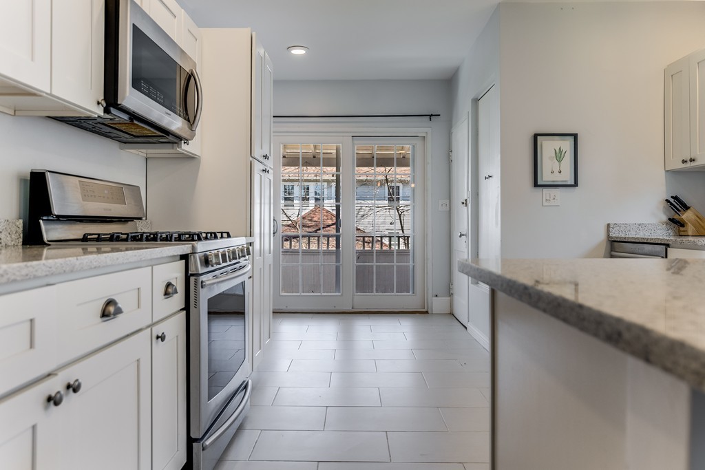 21 Pershing Road, Unit 2 Boston, MA 02130 - Photo 7 of 17 a kitchen with stainless steel appliances a stove a sink and a microwave