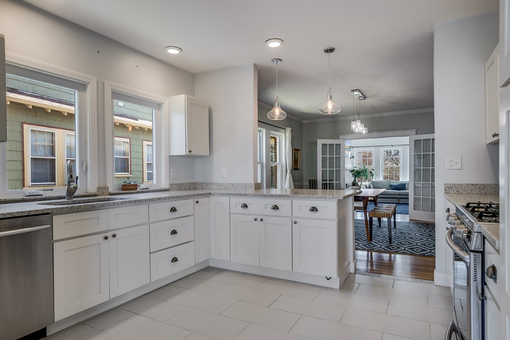 21 Pershing Road, Unit 2 Boston, MA 02130 - Photo 8 of 17 a large white kitchen with stainless steel appliances granite countertop lots of white cabinets a stove and a window
