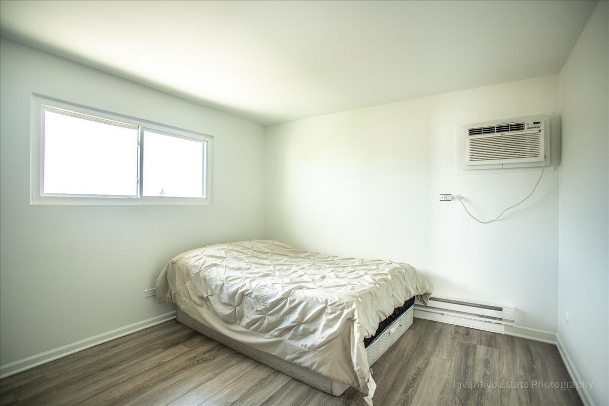 7345 West 85th Place, Unit 3A Bridgeview, IL 60455 - Photo 14 of 21 a bed sitting in a bedroom next to a window