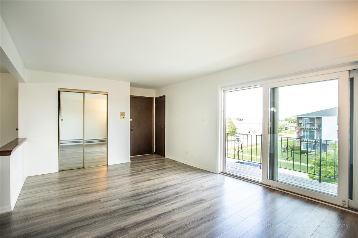 7345 West 85th Place, Unit 3A Bridgeview, IL 60455 - Photo 3 of 21 a view of an empty room with wooden floor and a window