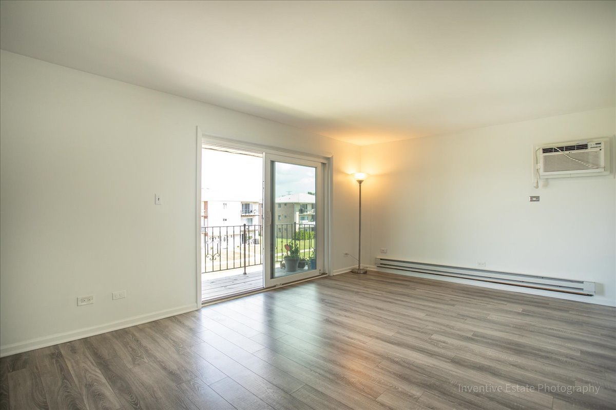 7345 West 85th Place, Unit 3A Bridgeview, IL 60455 - Photo 6 of 21 wooden floor in an empty room with a window