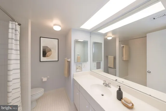 a bathroom with a bathtub shower sink vanity and toilet