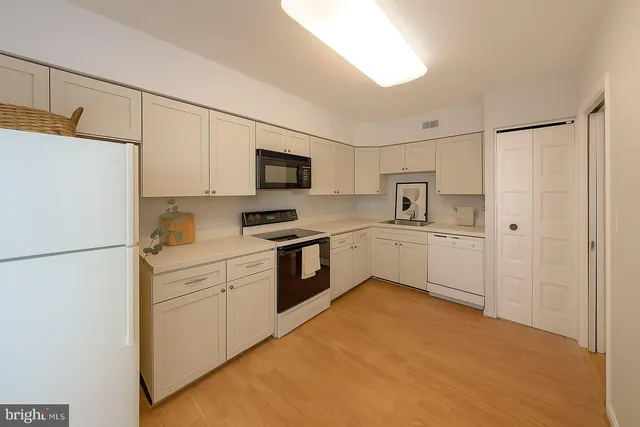 a kitchen with white cabinets and white appliances