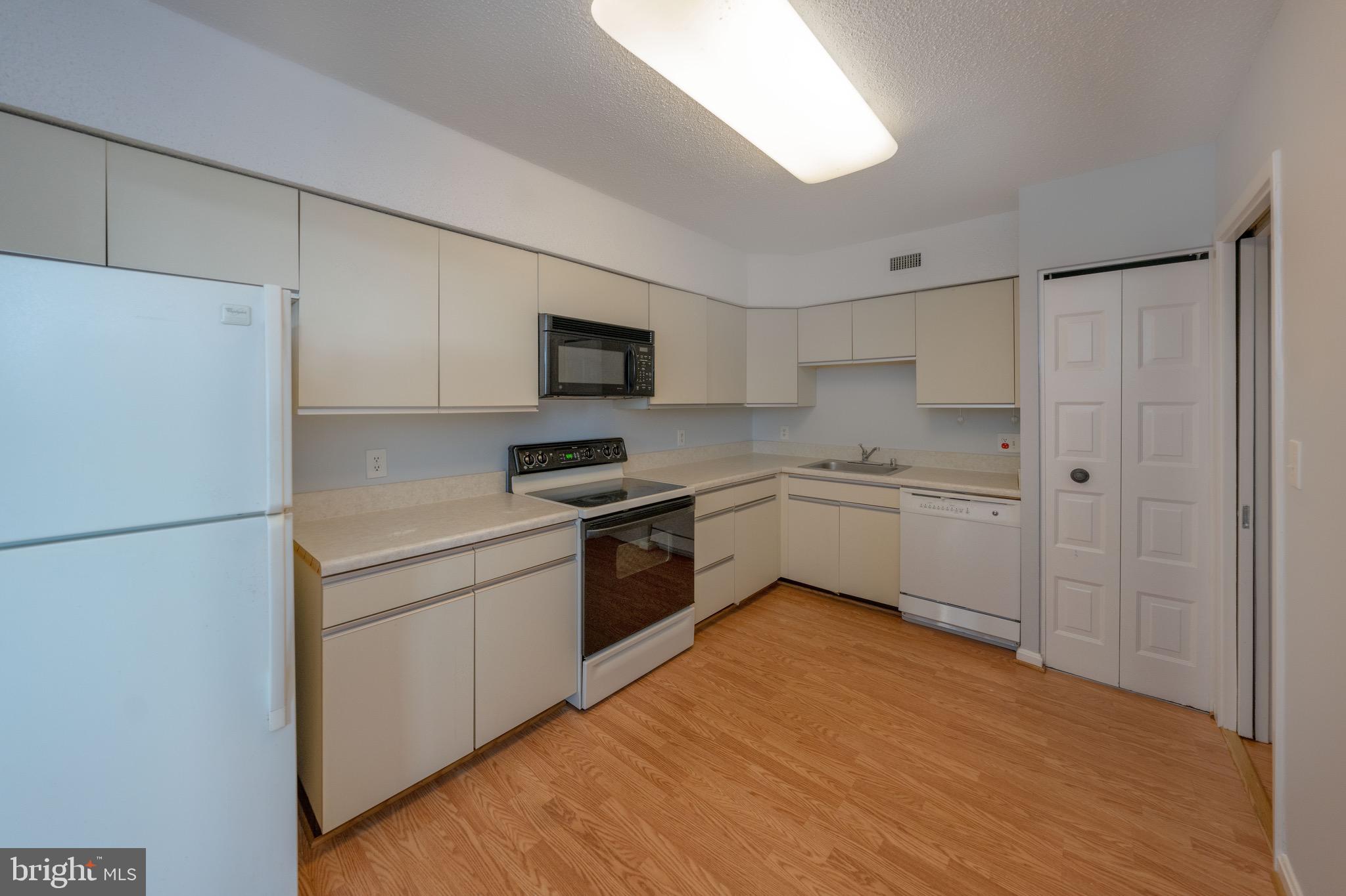 5501 Seminary Road, Unit 1113S Falls Church, VA 22041 - Photo 5 of 43 a kitchen with a refrigerator a sink and white cabinets