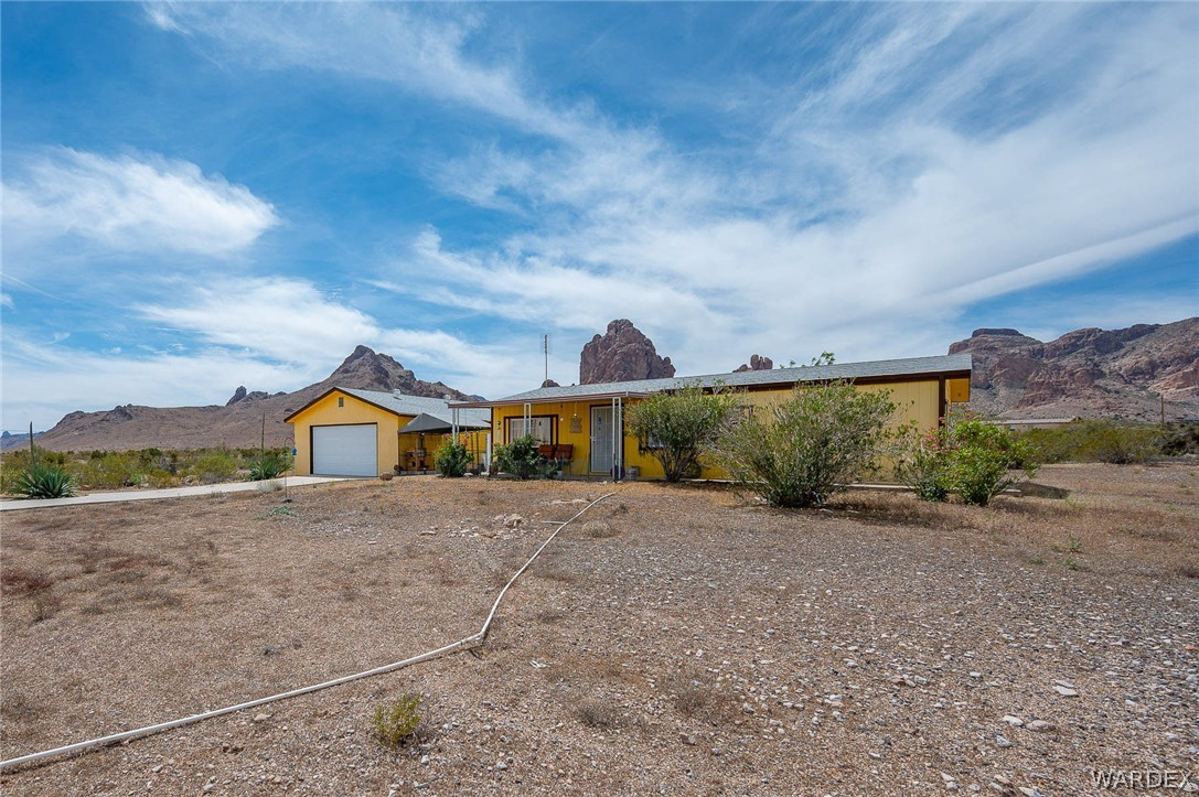 2465 Egar Road Golden Valley, AZ 86413 - Photo 71 of 98 The property features a yellow exterior and an attached garage with a white door