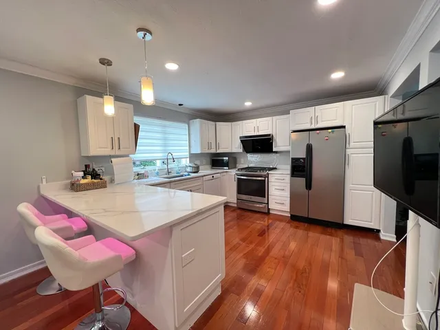 a kitchen with stainless steel appliances granite countertop a sink refrigerator and microwave