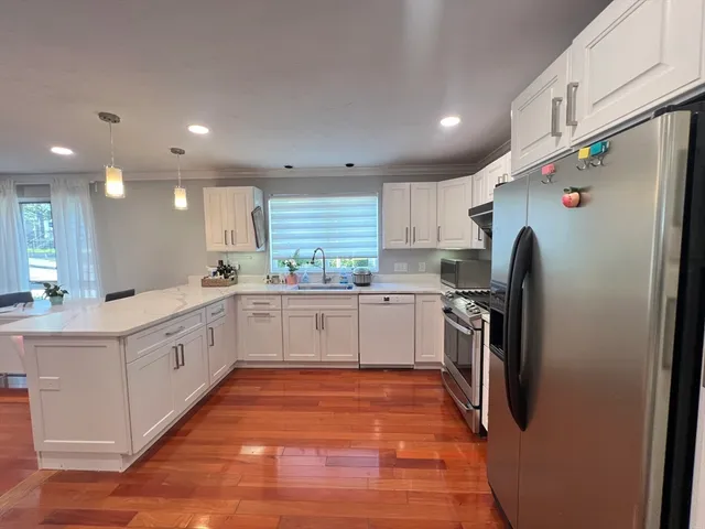 a large kitchen with stainless steel appliances sink and cabinets