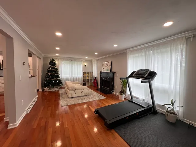 a room with gym equipment and wooden floor