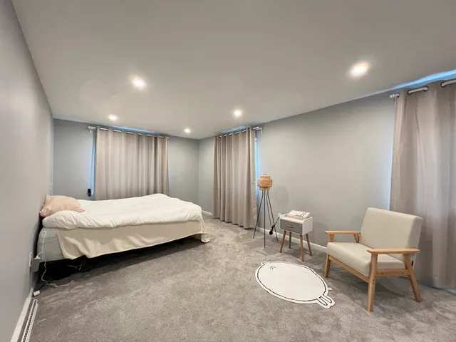 a spacious bedroom with a bed and a chair