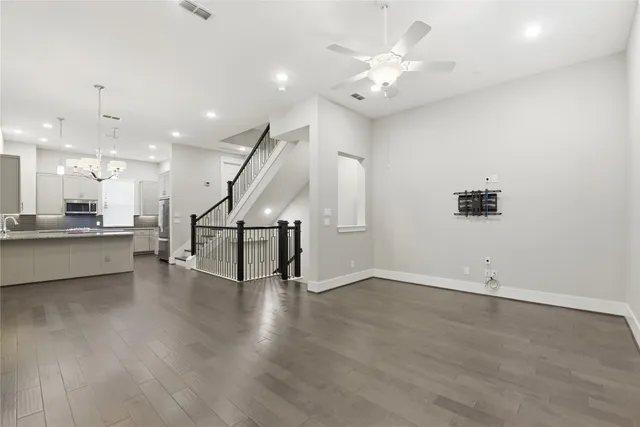 a view of an empty room with wooden floor and a large window