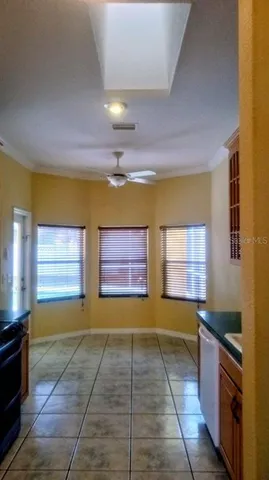 a view of an empty room with wooden floor and cabinets