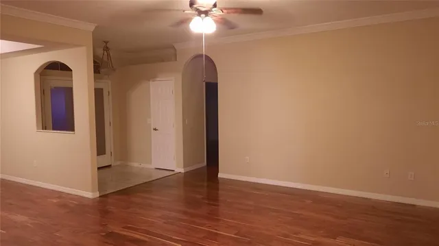 an empty room with wooden floor and a window