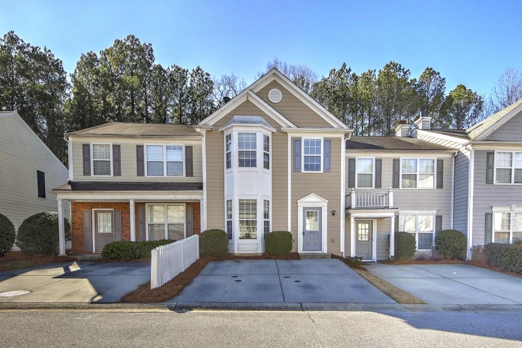 a front view of a house with yard and parking
