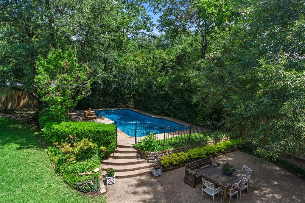 4315 Northaven Road Dallas, TX 75229 - Photo 36 of 40 The oversized backyard is a true private retreat, surrounded by mature trees and lush landscaping that create a peaceful, resort-style setting rarely found in Dallas. Enjoy a sparkling pool, expansive patio spaces perfect for entertaining, and an additional large grassy yard with a charming deck area — ideal for outdoor gatherings, play, pets, or simply relaxing under the trees.With multiple outdoor living spaces, this home offers the perfect blend of privacy, nature, and functionality, creating an exceptional indoor-outdoor lifestyle.