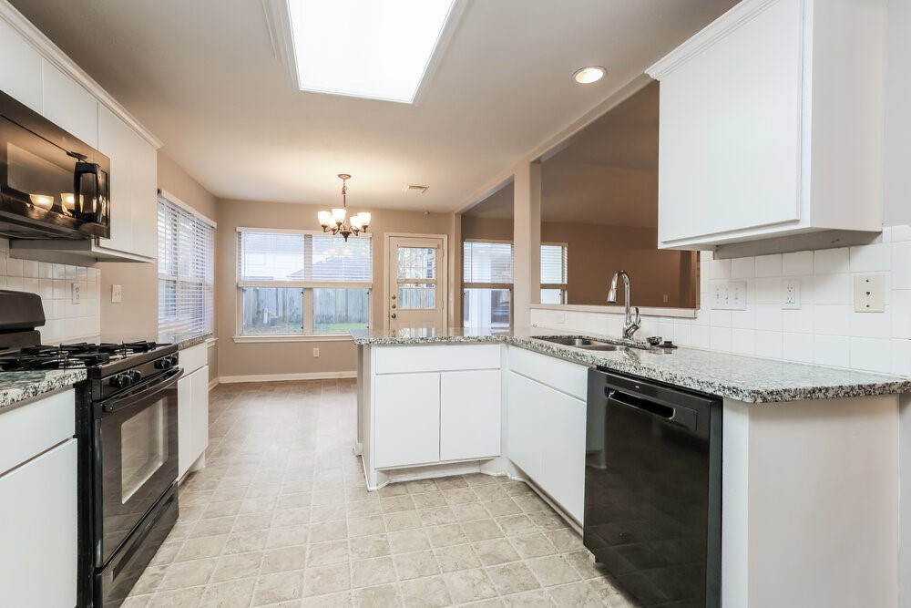 3219 Candlepine Drive Spring, TX 77388 - Photo 9 of 16 a kitchen with stainless steel appliances granite countertop a stove a sink and a refrigerator