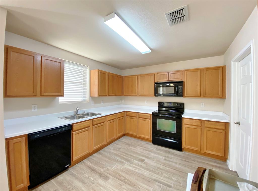 5511 Green Ivy Road Denton, TX 76210 - Photo 3 of 12 a kitchen with stainless steel appliances granite countertop a stove sink and cabinets