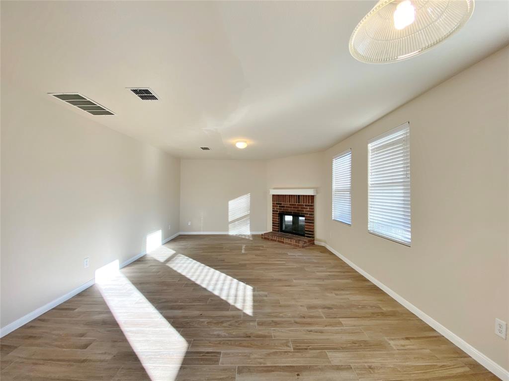 5511 Green Ivy Road Denton, TX 76210 - Photo 4 of 12 a view of an empty room with wooden floor and a window