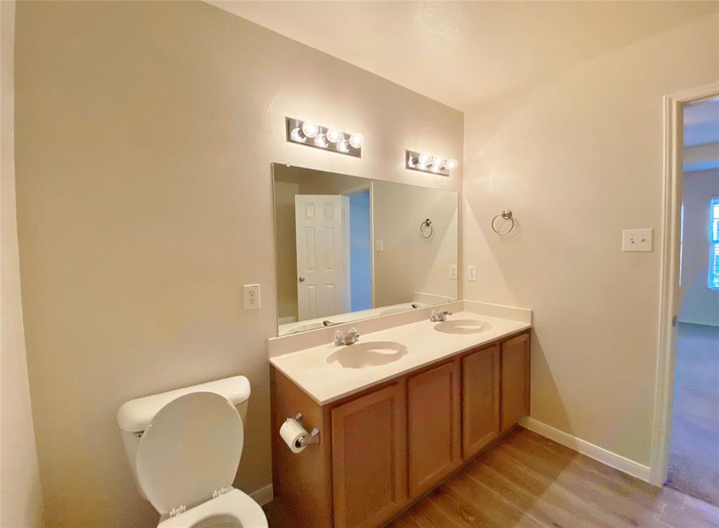 5511 Green Ivy Road Denton, TX 76210 - Photo 7 of 12 a bathroom with a toilet sink and mirror