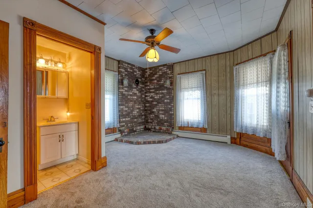 a view of empty room with window and ceiling fan