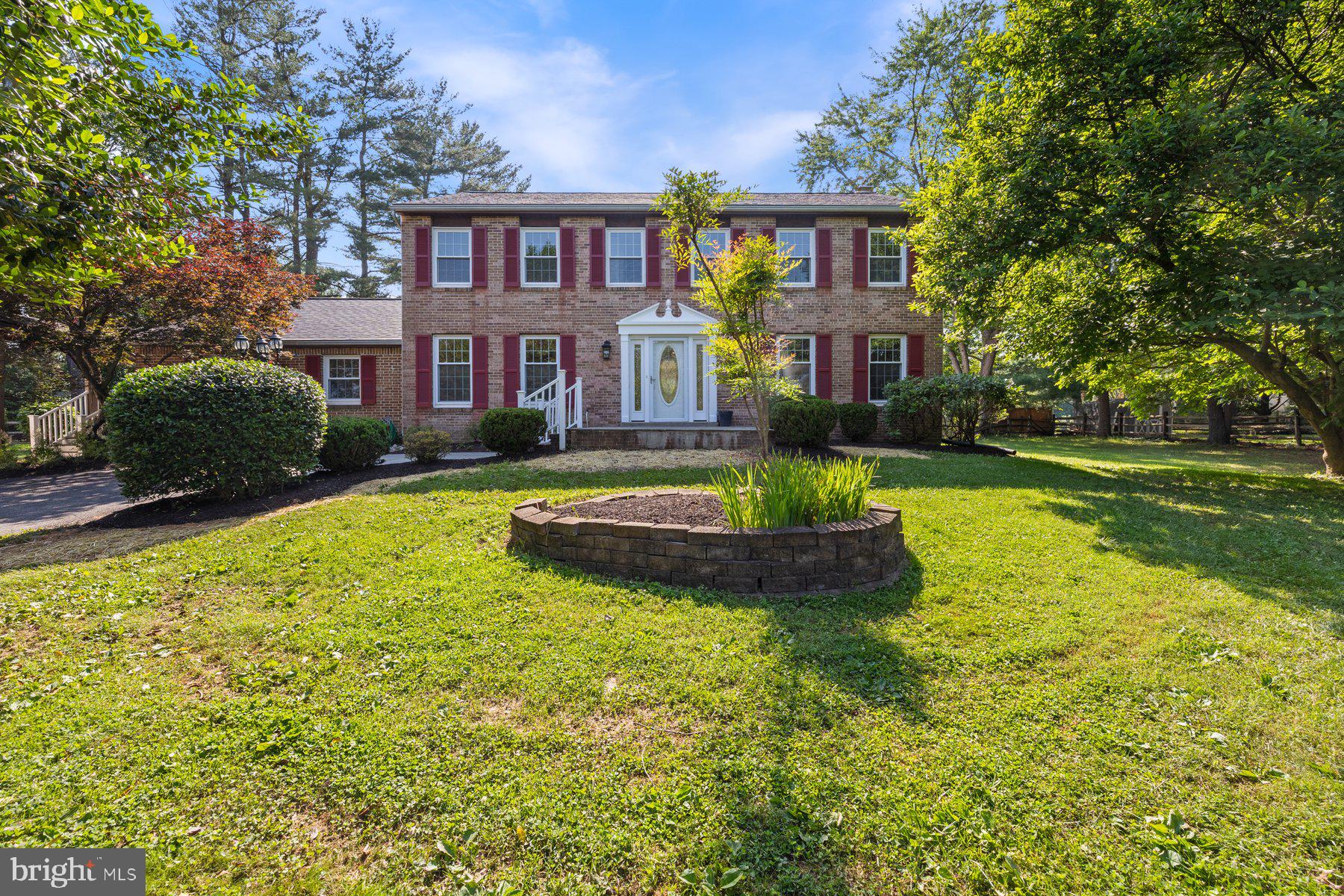 a view of a big yard in front of a brick house with a large windows
