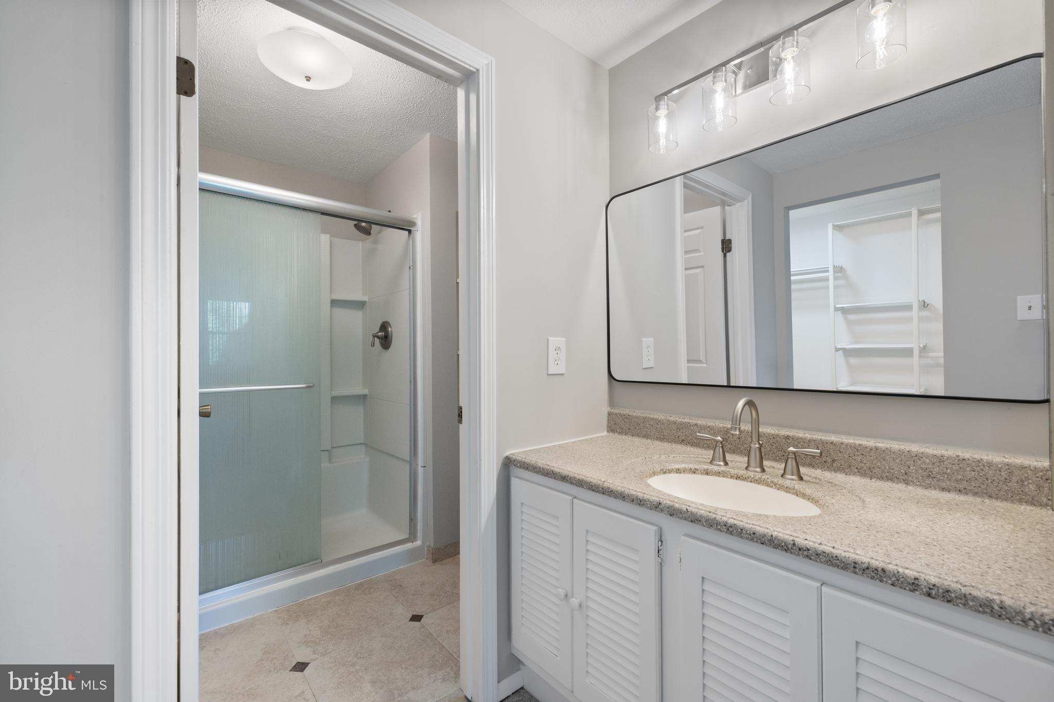22000 Goshen School Road Gaithersburg, MD 20882 - Photo 43 of 57 a bathroom with a granite countertop sink shower and mirror