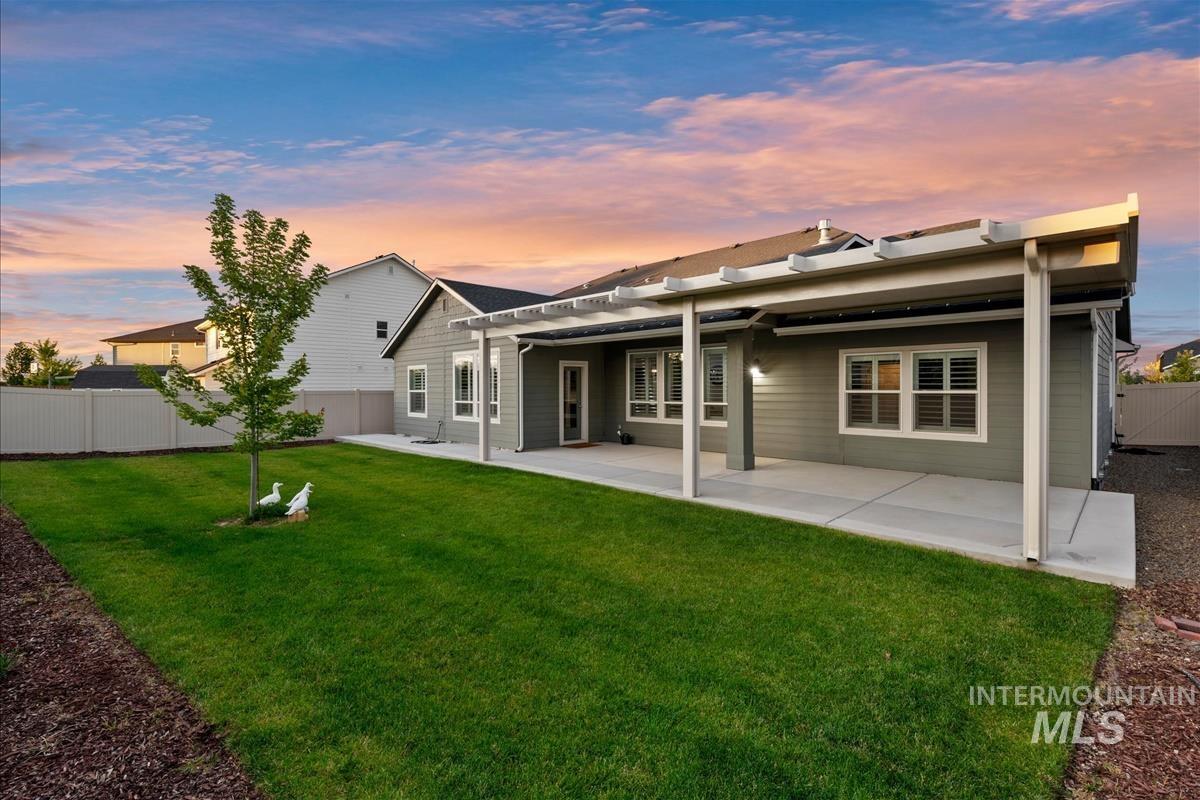 15451 Lutsen Avenue Caldwell, ID 83607 - Photo 37 of 39 Expansive backyard featuring a lush lawn, concrete patio, and a pergola for shaded outdoor living