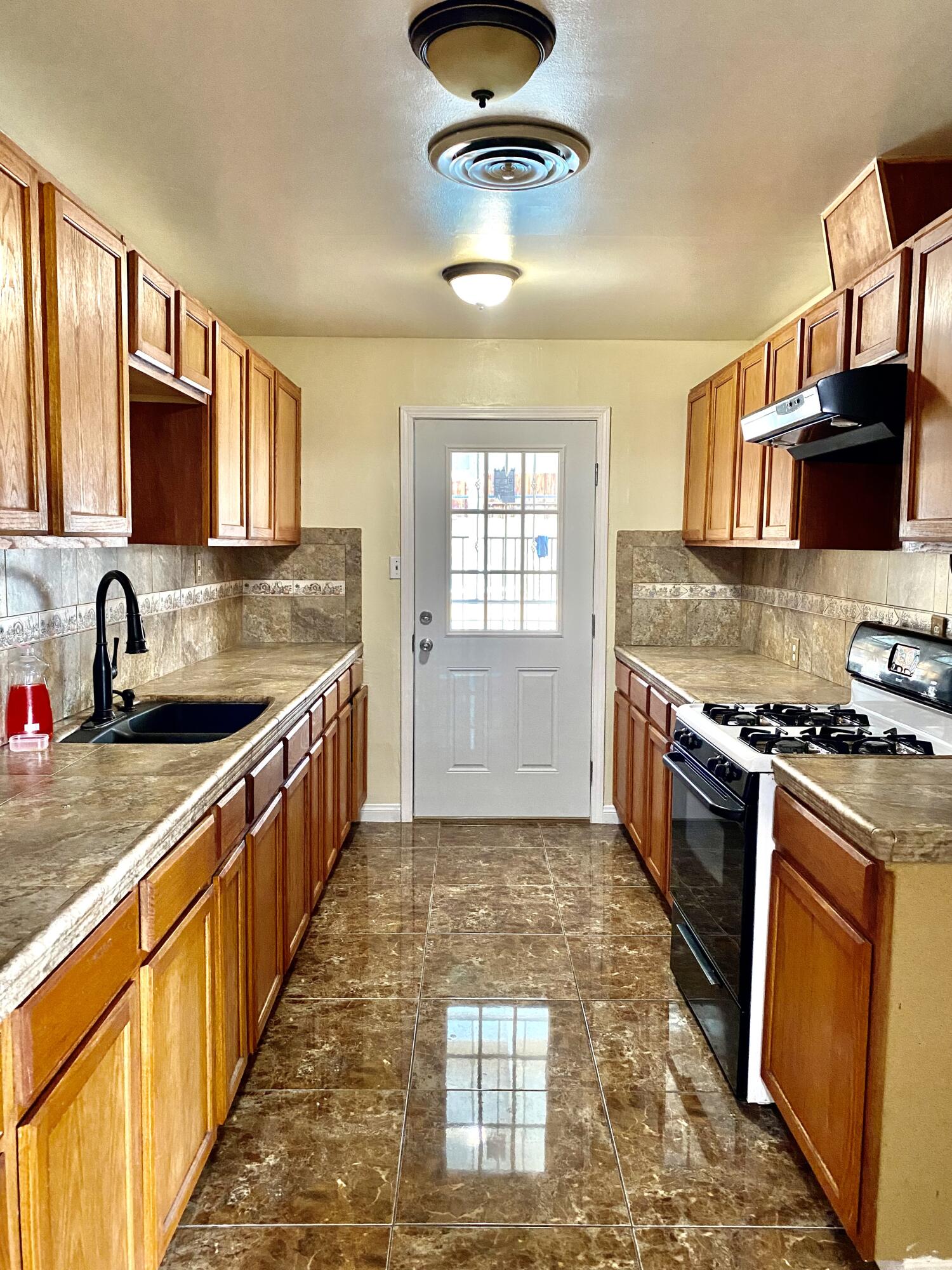 6916 Azalea Avenue Bakersfield, CA 93306 - Photo 5 of 26 a kitchen with stainless steel appliances granite countertop a sink stove and cabinets