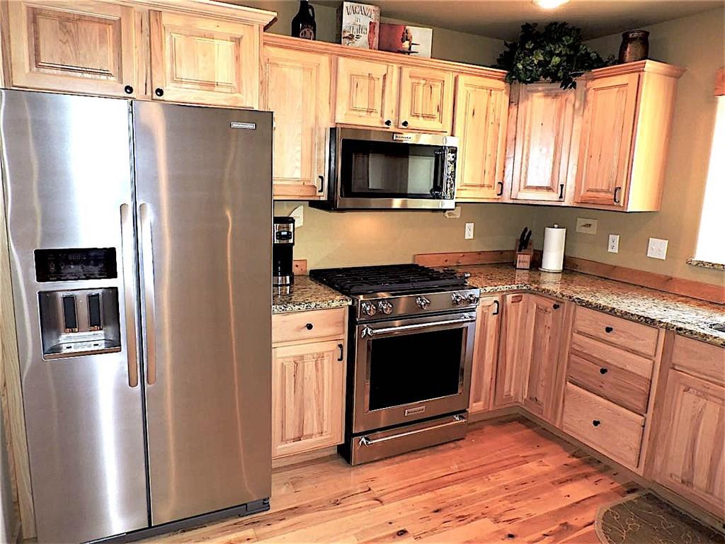 299 Gadwall Road Como, CO 80432 - Photo 7 of 25 a kitchen with granite countertop a refrigerator stove and microwave