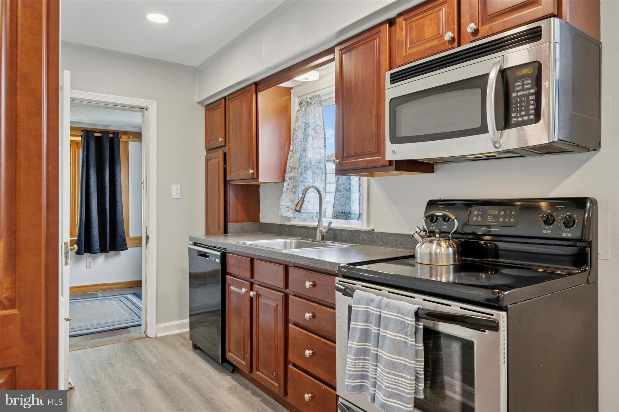 181 Friendship Road Drexel Hill, PA 19026 - Photo 10 of 24 a kitchen with stainless steel appliances granite countertop a stove a sink and a microwave