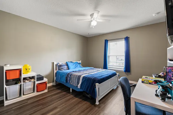 a bedroom with a bed and wooden floor