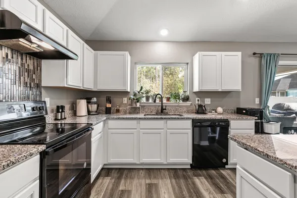 a kitchen with a sink stove top oven and cabinets